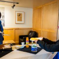 President Mantella flipping a pancake onto the plate of a student.